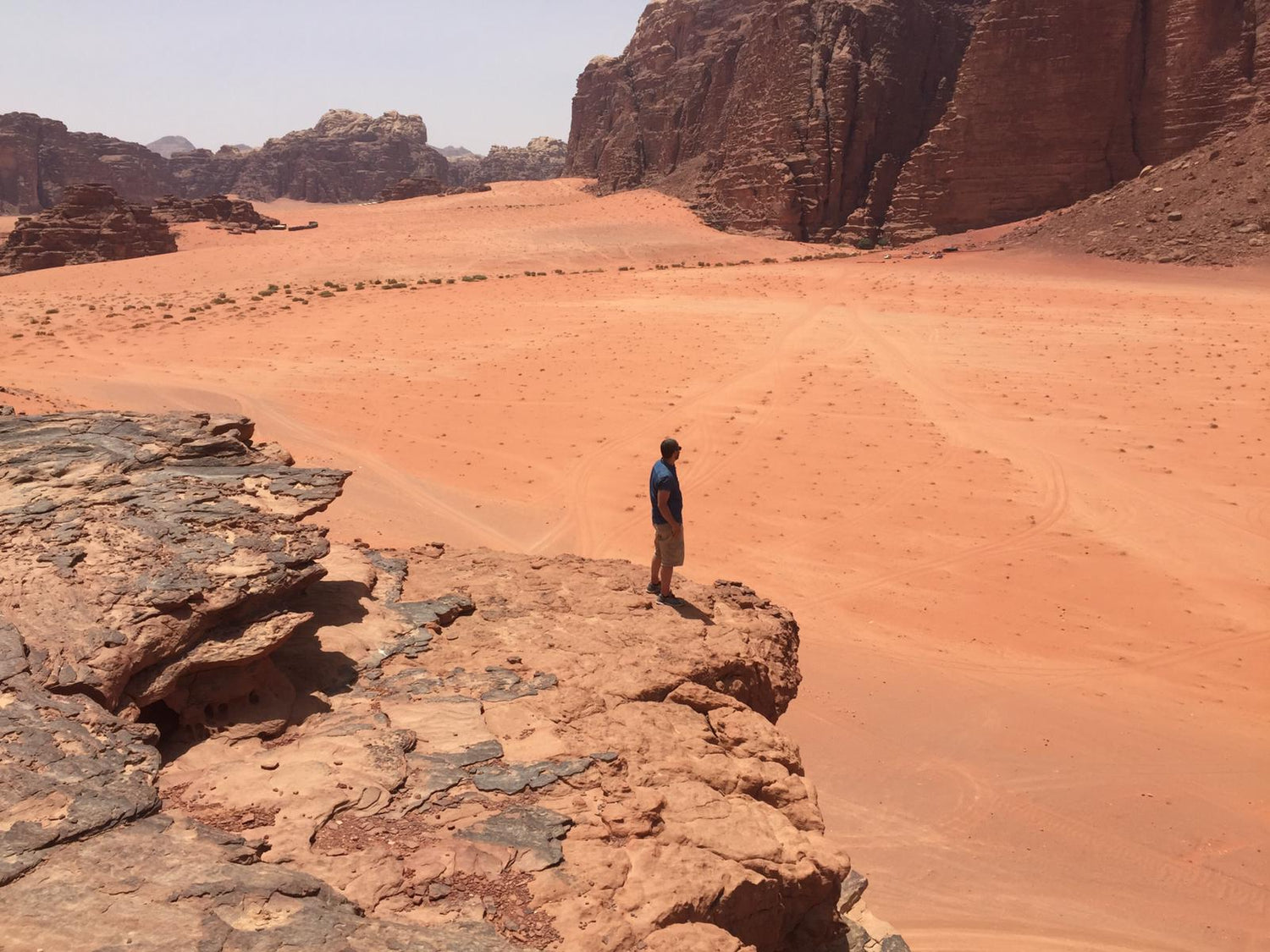 Silhouette humaine face à l’immensité d’un désert aux falaises rocheuses

